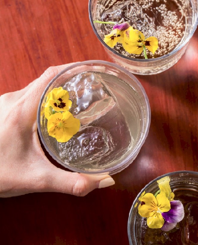Copa con hielo y flores sobre una mesa de madera